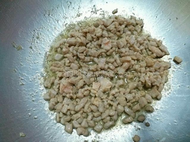 锅内放入适量食用油，烧热后放入猪肉丁，翻炒至肉丁变色断生。