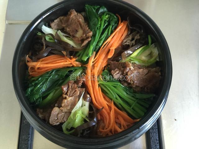将蔬菜码好放在米饭上，石锅放到燃气上，中火加热。