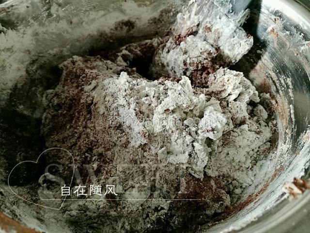 将巧克力豆（留下一小部分待用）倒入鸡蛋黄油糊中 拌匀 再将可可粉面粉倒入 用硅胶铲上下翻动 