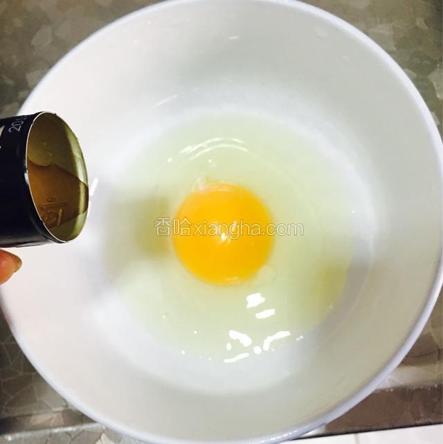 碗中先打入一个鸡蛋，加入两滴料酒和少许盐。