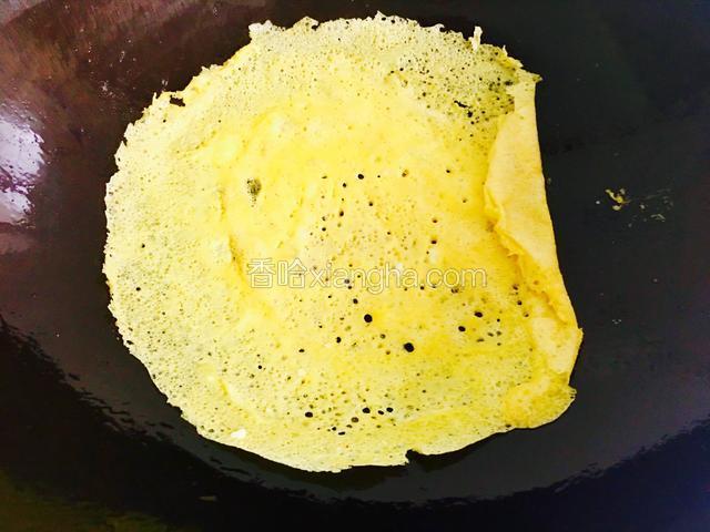 看到边缘微干翘起时就轻轻卷起翻面再煎一下。
