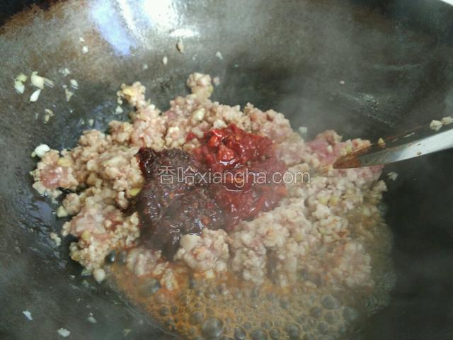 翻炒变色后加入豆瓣酱和牛肉酱继续翻炒