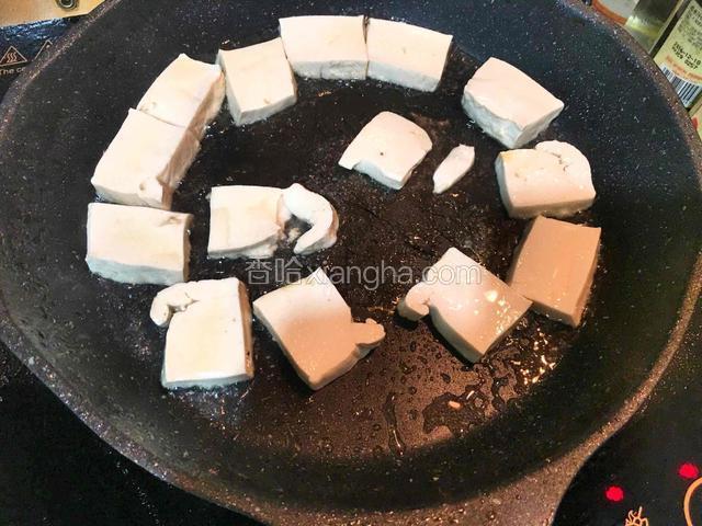 热锅倒油，放入豆腐块煎至两面金黄后盛出备用