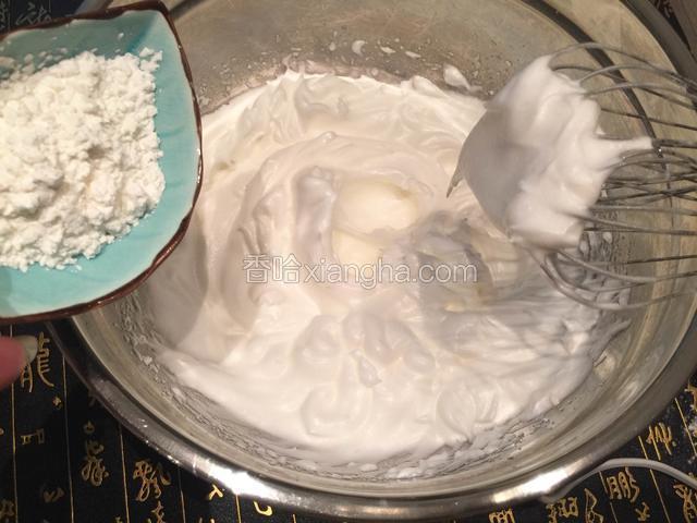 打至提起打蛋头，蛋白霜呈大弯钩时，加入剩余的细砂糖和10克玉米淀粉；