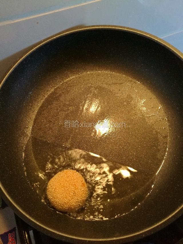 把锅的一边垫高，这样油就会流到一边，不用很多的油。把面团稍微按扁放在油锅里。