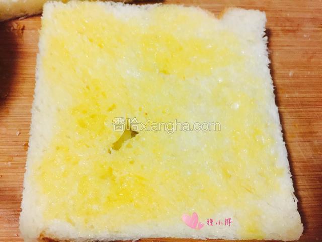 吐司的一面抹上黄油。