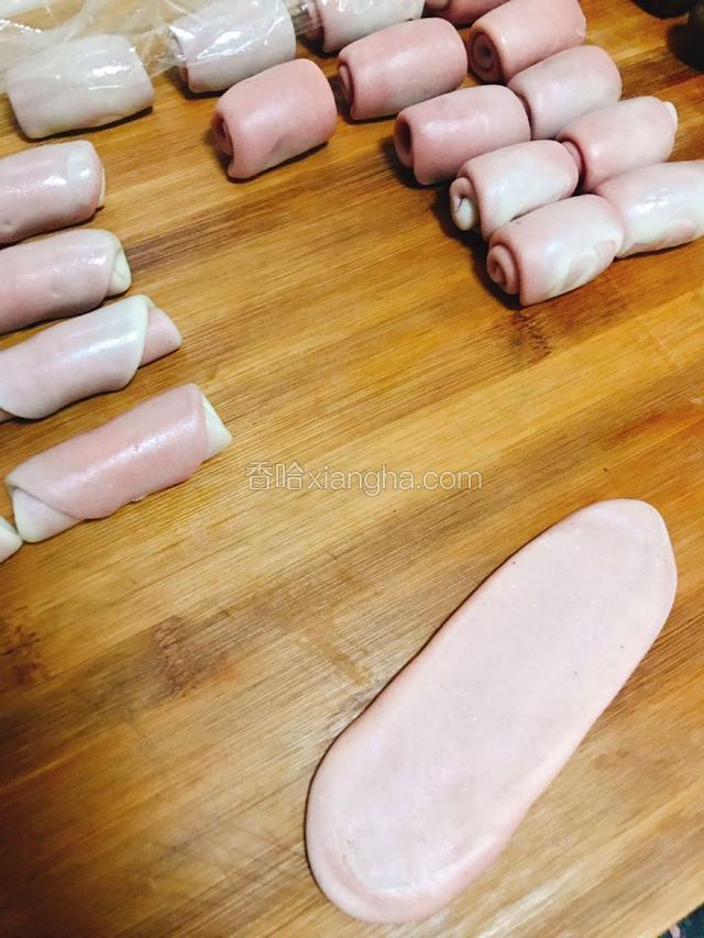 擀成牛舌状。从下用手心搓起，大致能卷起3-4圈。

全部擀好后盖膜松弛20分钟。

然后重复上一步骤，把面擀成牛舌状，卷起，盖好膜，松弛20分钟备用。