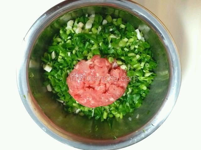 把猪肉馅放入葱末盆中。