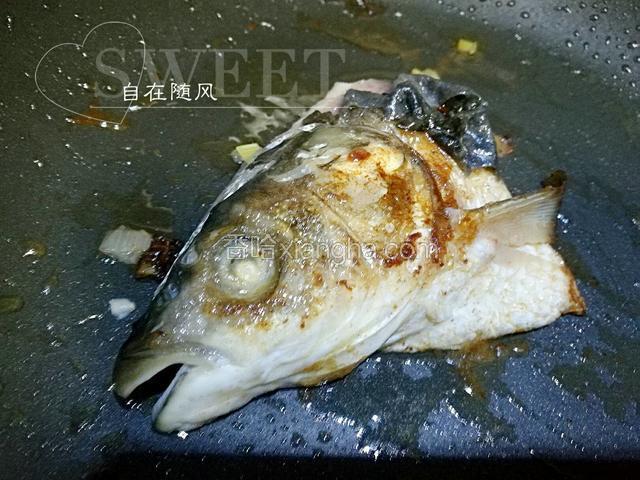 锅中油热 将鱼头放入 两面炸金黄 蒜瓣一起炸一下