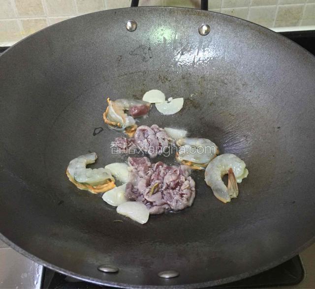 火候调大，再倒进虾仁和瘦肉。
翻炒几下。