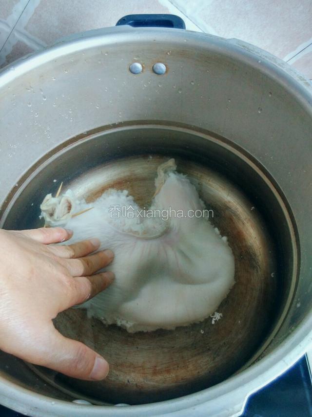 用手压一压猪肚，猪肚开口处会冒出气泡，将猪肚中的空气排出，然后将锅烧开。