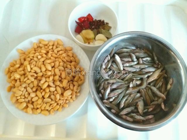 准备食材，把小鱼清洗干净，将黄豆提前浸泡1夜后控干水份，把大蒜去皮并洗净，把香叶、花椒、红椒段洗净。