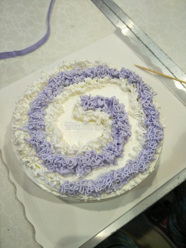 用紫色奶油按照画好的形状挤出奶油，再用白色奶油把控的地方挤出白色奶油