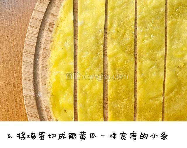 鸡蛋切成跟黄瓜一样宽度的小条宝餐提示：可以用一片黄瓜条放在蛋饼上，比对着黄瓜片切