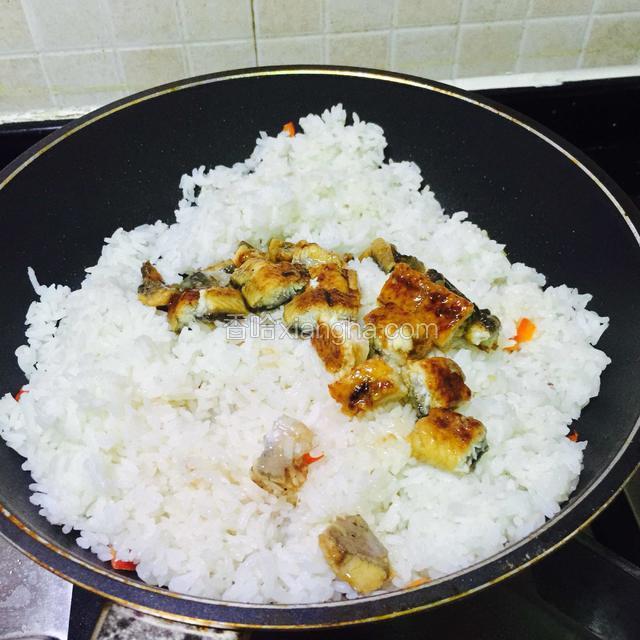 倒进米饭，翻炒均匀受热，
倒进鳗鱼粒，调小火。
鳗鱼是熟食，可以不用这么快下锅，但是因为是冰冻过，所以提早跟米饭一起炒。