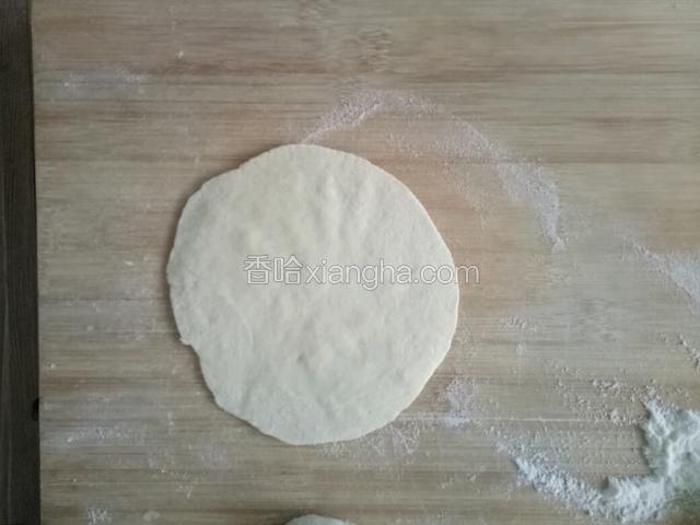 按扁，用擀面杖擀成中间厚两边薄的包子皮，比饺子皮厚
