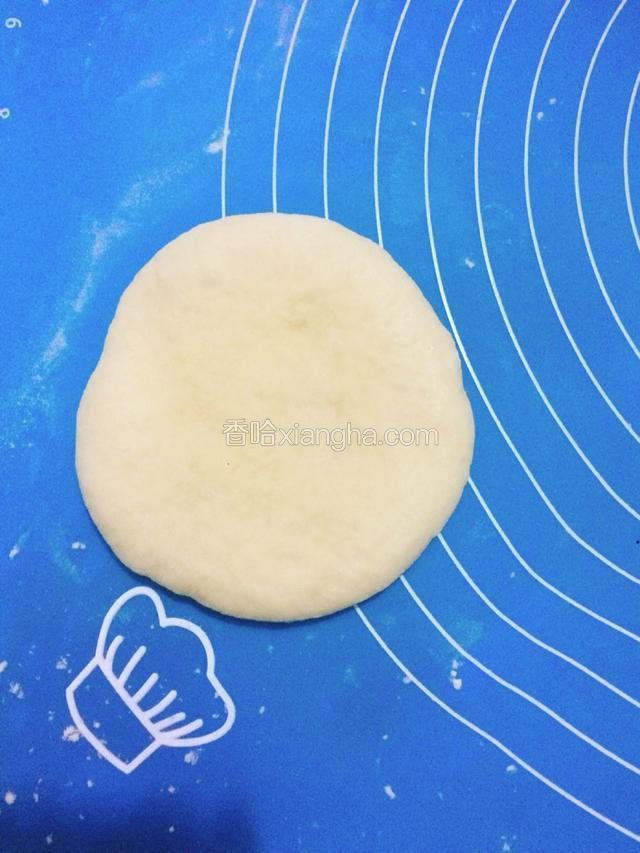 松弛好的面团用手按扁。