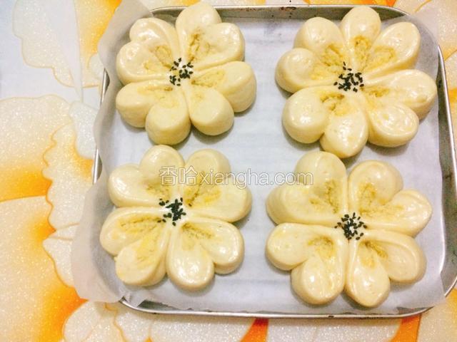 面包胚大了一圈后，在表面刷上一层全蛋液，然后在中间撒上少许黑芝麻。