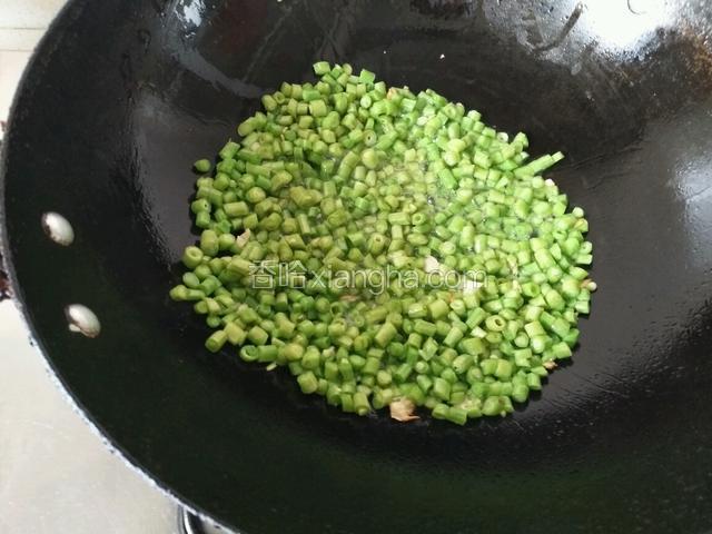 锅中倒适量油下蒜末爆香，倒入豆角粒
