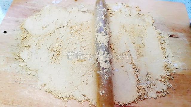 倒在案板上用擀面棒把糖疙瘩擀碎。