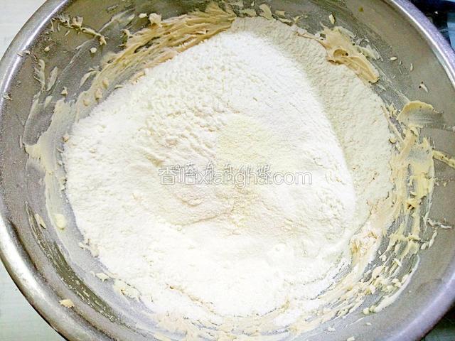 低粉和奶粉提前过筛两遍后筛入黄油中。