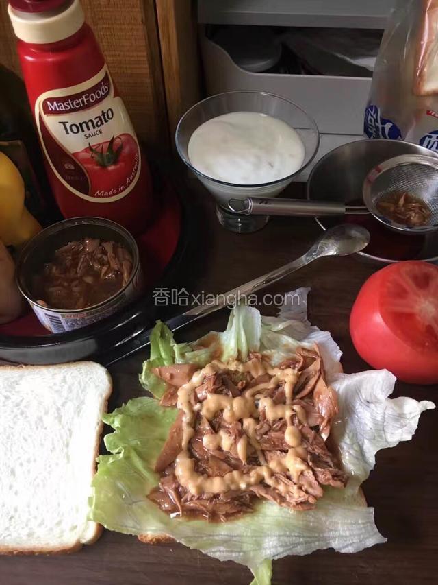 先放好西生菜，然后控去金枪鱼罐头里的水分铺在生菜上面，挤上千岛酱。