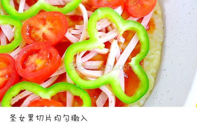 香肠切丝均匀撒入，青椒切片均匀放入，圣女果切片均匀放入，再均匀撒入芝士宝餐提示：披萨的馅料可以用任何宝宝喜欢的
