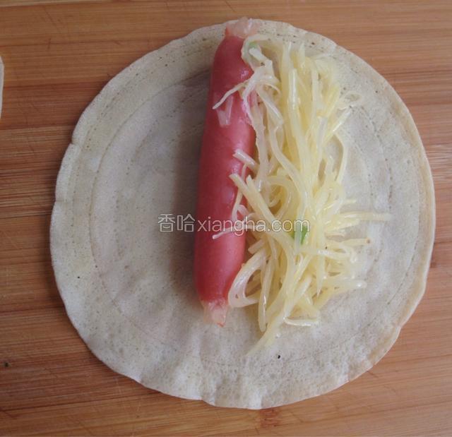 取饼一张，把香肠和土豆丝放在上面