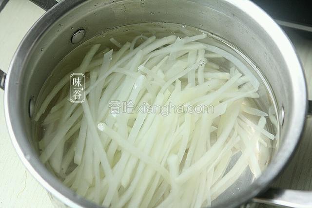 捞起土豆丝沥干水，放入凉白开内浸泡，几分钟后捞出控干水。