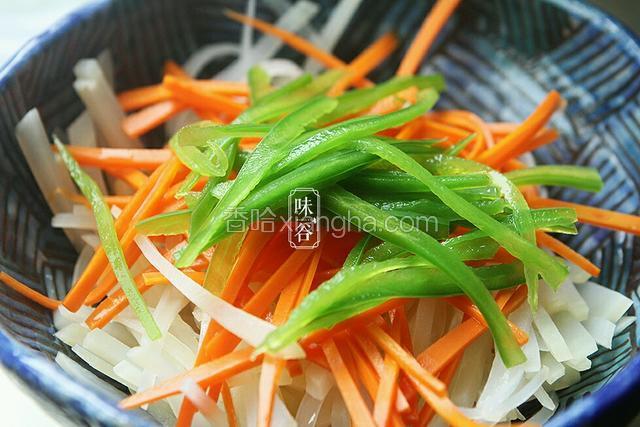 放入胡萝卜丝和青椒丝焯1分钟左右，捞起放入凉白开内浸泡。把土豆丝和胡萝卜丝和青椒丝放入碗内备用。