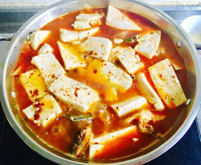 将鱼骨汤转入小锅中，把豆腐平铺在鱼骨上面，煮开后转中小火炖15分钟。