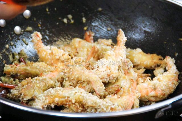 依次放入炸好的虾，盐，料酒，生抽煸炒