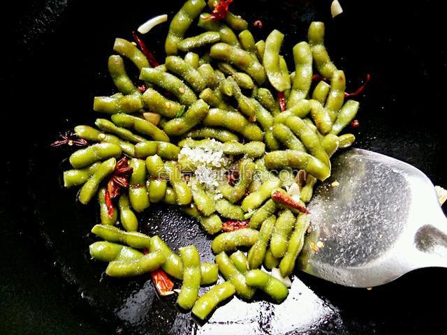 倒入毛豆放适量糖、盐、生抽翻炒均匀
