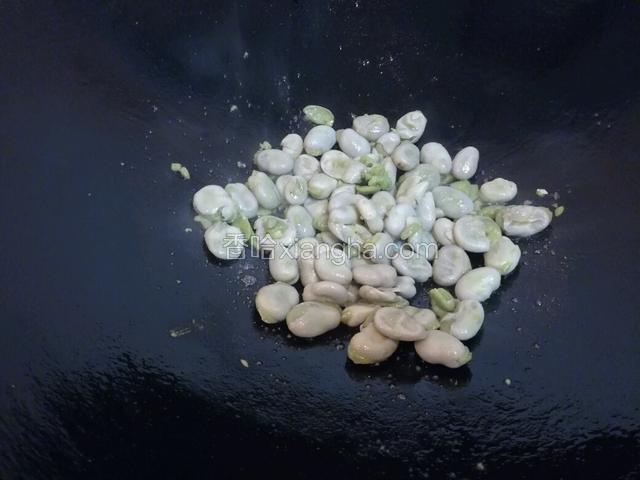 加入蚕豆翻炒焖煮，并用力压扁。