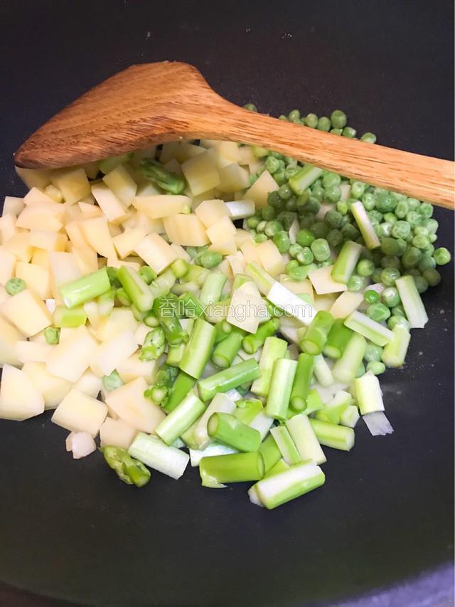 依次加入土豆丁芦笋和豌豆炒片刻