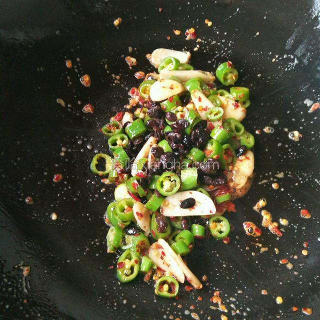 锅里还有点底油，放入蒜片和辣椒中火爆香，再倒入豆豉翻炒