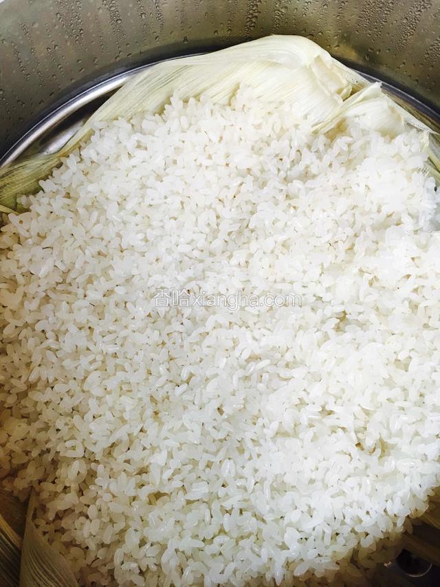 把泡好的糯米控干水放进蒸锅里，我下面铺的是玉米叶子，哈，没有屉布！大概20到25分钟即可！尝一尝就知道熟没熟了！