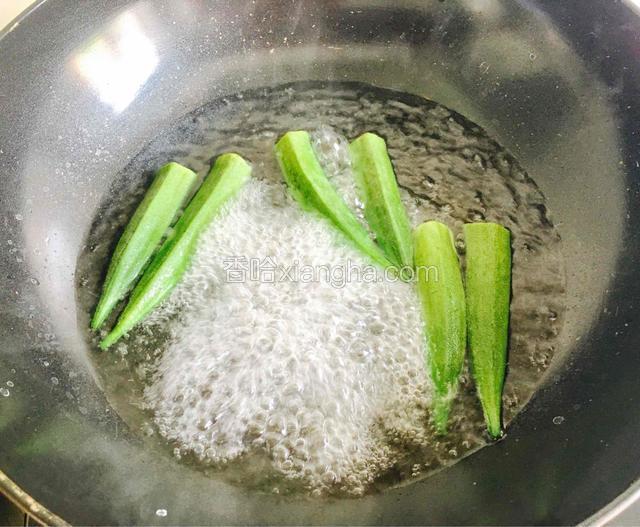 锅中烧开水加盐放入秋葵汆煮3分钟，秋葵煮至颜色变深捞起过凉水。
