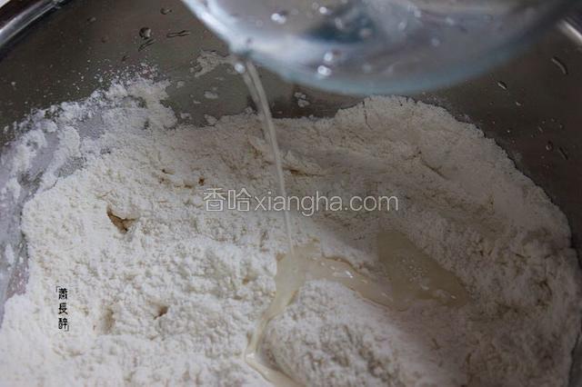 面粉中加适量冷水，开始搅拌。