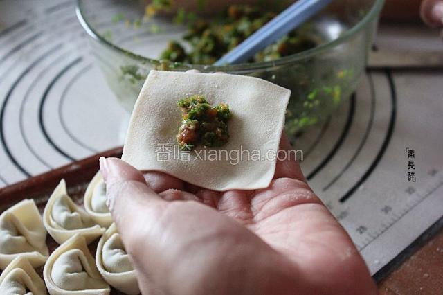 取少量肉馅放入面皮中。
