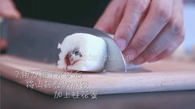 用刀蘸了水以后，将山药卷切成段。