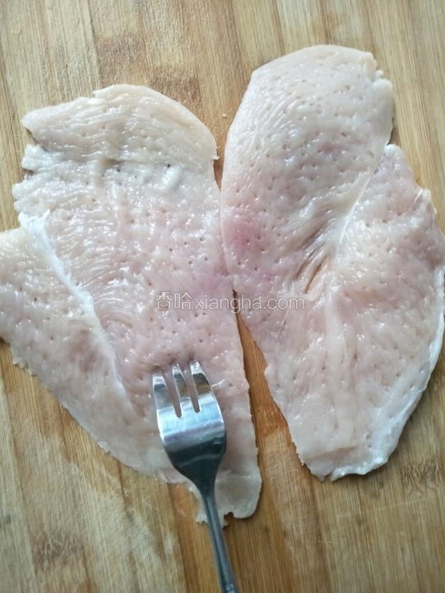 用刀切成两片，用叉子在鸡肉上扎上小孔