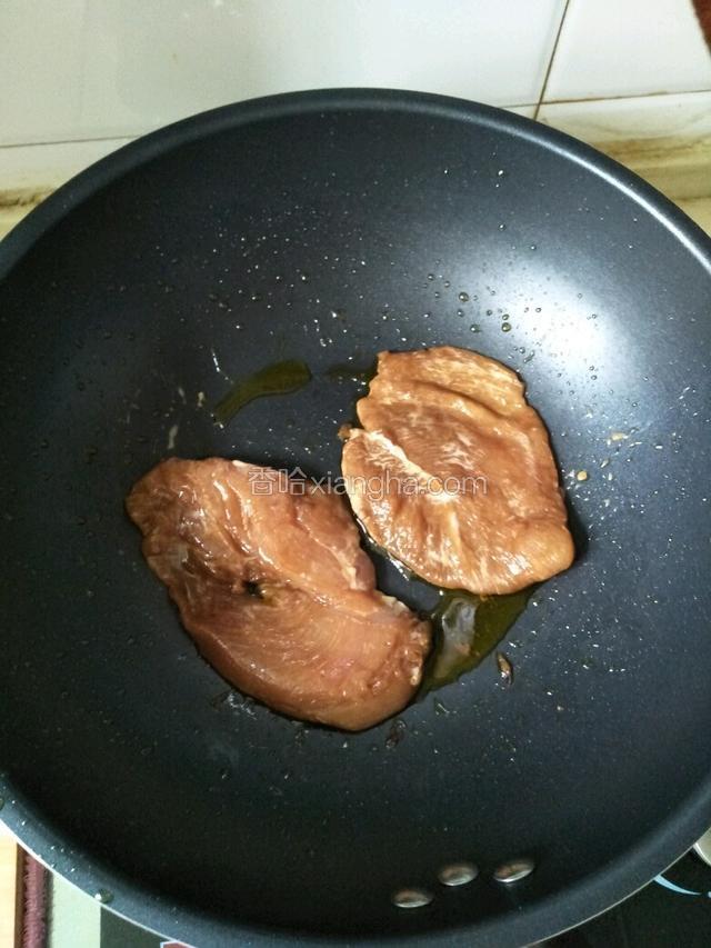 锅中倒入少量油，放入鸡肉煎