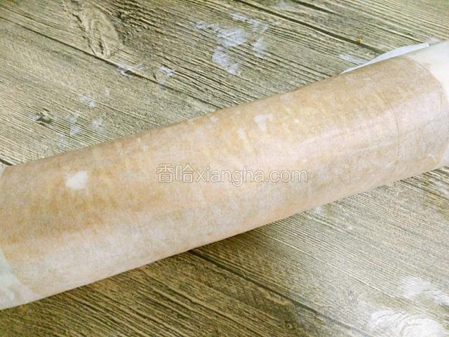 借助吸油纸把蛋糕卷起来，放入冰箱冷藏一个小时左右