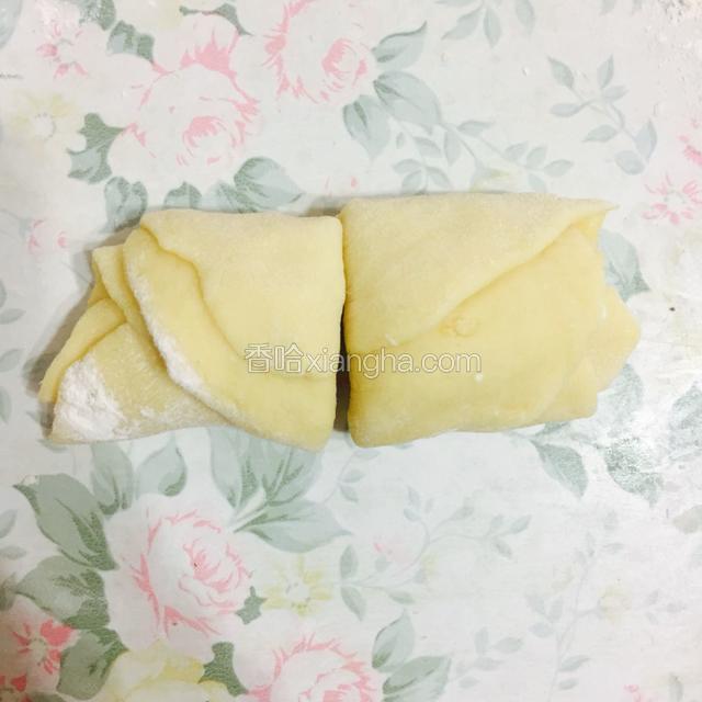 将小面团擀成饼，五个叠加在一起卷成卷后，用刀在中间切成两半