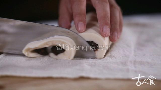 在芸豆皮左右挤两条豆沙馅，将芸豆皮卷住豆沙馅，捏实。
