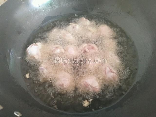 锅中放宽油烧至六成热时，放入鸡块炸至