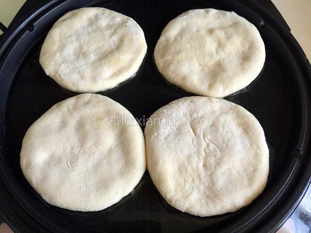 约30分钟后预热电饼铛，放入玉米油，放入面饼烙制。