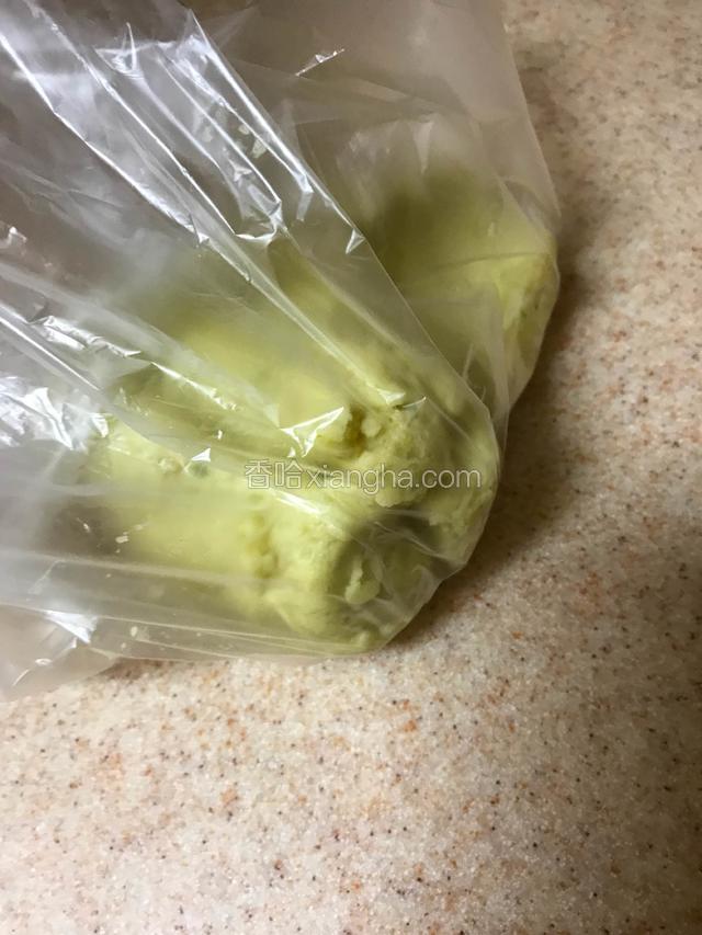 取一个大一点的保鲜袋，用刮刀将拌匀的面团装入。