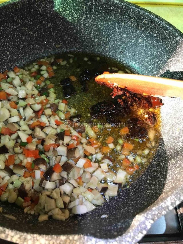 将菜拨到一边，舀入一勺老豆瓣炒出红油。